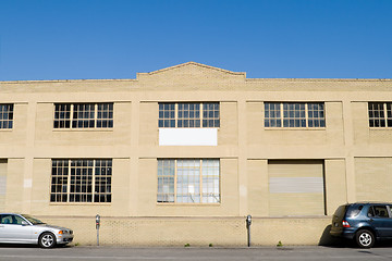 Image showing Exterior of Old Warehouse, Street, Parked Cars, Blue Sky