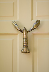 Image showing Lobster Shaped Door-Knocker On Yellow Wooden Door