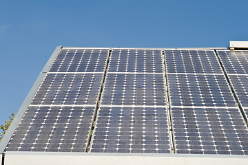 Image showing Row of Solar Panels on Roof Against Blue Sky