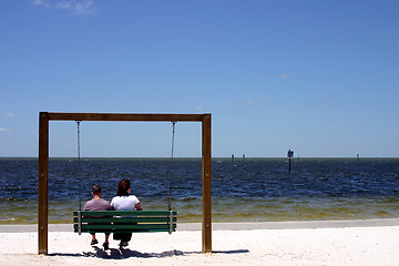 Image showing Couple sitting on a swing at the beach