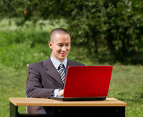Image showing man with laptop working outdoors