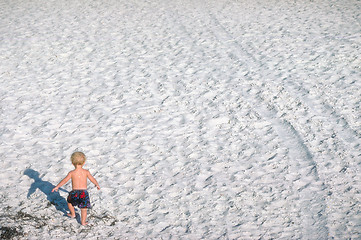 Image showing Small boy walking on beach