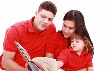 Image showing Family sitting on floor reading book at home