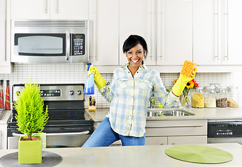 Image showing Young woman cleaning kitchen