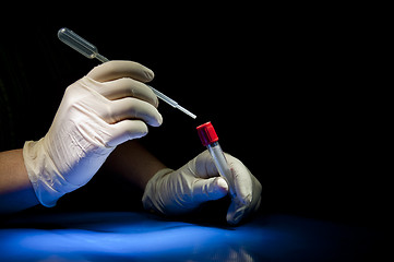 Image showing Hands in white gloves hold pipette