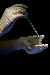 Image showing Hands in white gloves hold pipette