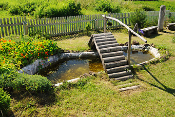 Image showing small garden pond with wooden bridge