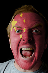 Image showing Face of crazy angry man painted in colors of Chna flag