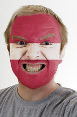 Image showing Face of crazy angry man painted in colors of latvia flag