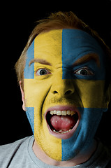 Image showing Face of crazy angry man painted in colors of sweden flag