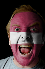 Image showing Face of crazy angry man painted in colors of latvia flag