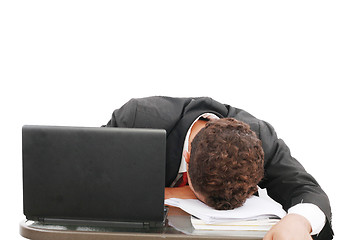 Image showing A portrait of a tired businessman resting his head on books over