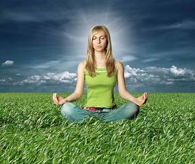 Image showing Blonde in lotus pose in green grass