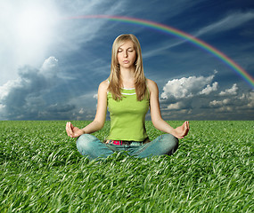 Image showing Blonde in lotus pose in green grass