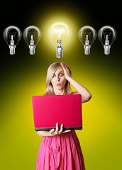 Image showing blonde in pink dress with laptop and bulb