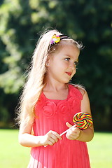 Image showing Little girl  with candy in his hands.