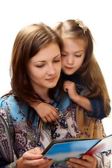 Image showing Young woman reads a book a little girl.