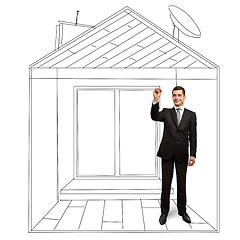 Image showing businessman with marker in fictional house