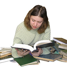 Image showing Student girl reading on the heap of books