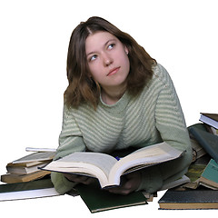 Image showing Student girl reading on the heap of books