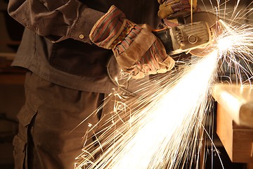 Image showing Worker with angle grinder only hands