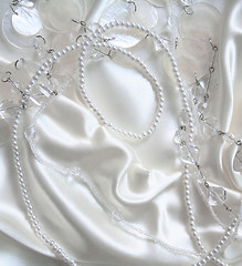 Image showing White pearls and nacreous beeds on white silk as wedding backgro