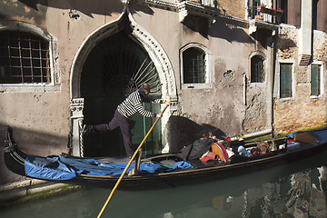 Image showing Gondolier driving in a narrow canal