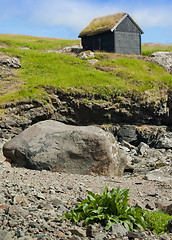 Image showing Wood storehouse with grass roof