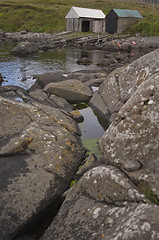 Image showing Boat houses with rocks in the foreground