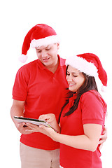 Image showing Happy Christmas couple looking a tablet computer. Isolated on wh