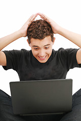 Image showing young man shocked with something he see on his laptop computer 