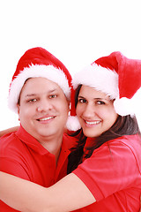Image showing Young happy couple near with Santa hats. Isolated over white bac