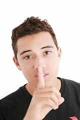 Image showing young man with finger on his mouth isolated over white backgroun