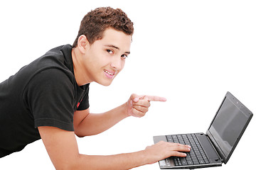 Image showing Young student is lying on the floor and looks  his laptop. Isola