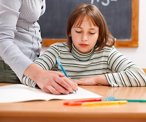 Image showing Teacher showing writing to schoolgirl