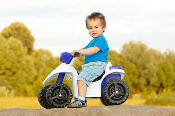 Image showing Little boy sitting on toy quad