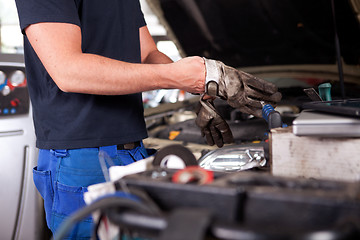 Image showing Mechanic Putting on Work Gloves