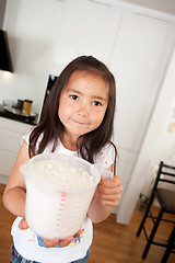 Image showing Young Girl Baking Measuring Cup of Flour