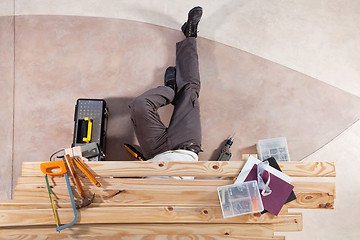 Image showing Man working under wooden plank