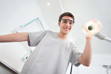 Image showing Dentist adjusting lamp