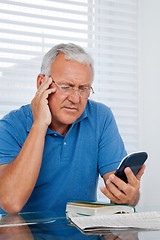 Image showing Senior Man Holding Calculator