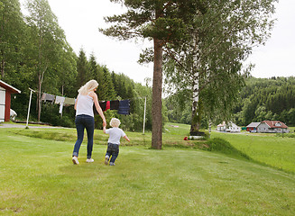Image showing Woman and child walking in garden