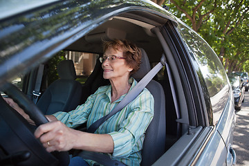 Image showing Smiling senior woman driving car