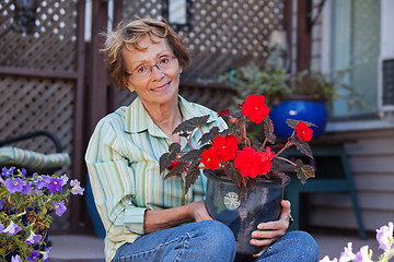 Image showing Senior woman holding potted plant