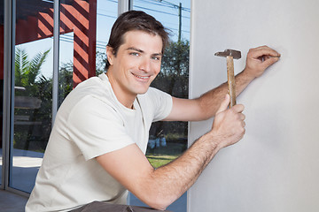 Image showing Man hammering the wall