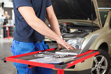 Image showing Mechanic working on a laptop