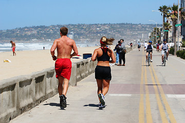 Image showing Couple running along the beach