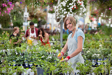 Image showing Beautiful woman spraying water on plants