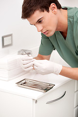 Image showing Dentist Inspecting Sterile Tool