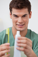 Image showing Dentist holding toothpaste and toothbrush